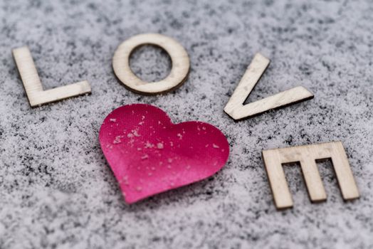 Valentine's Day. Heart of pink in the snow with the letters sweet. Valentine's Day. Soft focus. Background. Close-up.Heart drawn in the snow.
