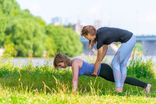 An experienced trainer practices yoga on an individual basis, outdoor sports in the park