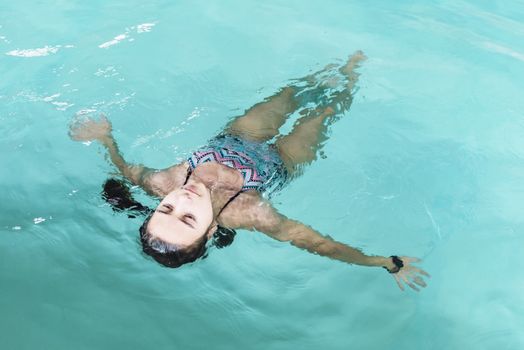 Beautiful girl swim and having fun in water.Active holiday.Girl swim in the pool. Happy girl play in the pool.