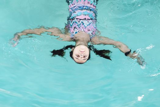 Beautiful girl swim and having fun in water.Active holiday.Girl swim in the pool. Happy girl play in the pool.