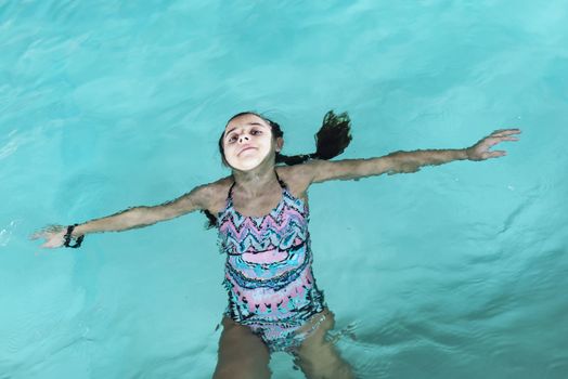 Beautiful girl swim and having fun in water.Active holiday.Girl swim in the pool. Happy girl play in the pool.