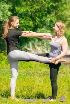 balance exercise, yoga with a trainer in a summer park