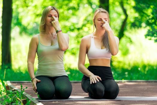 Woman 40 years old with a trainer perform breathing exercises with a trainer in the open air