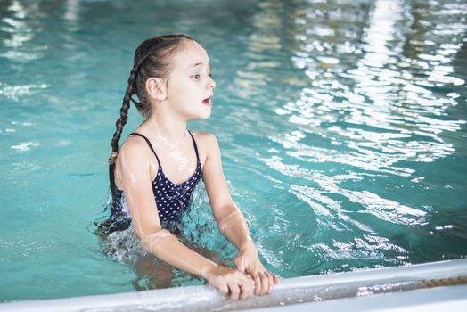 Beautiful girl swim and having fun in water.Active holiday.Girl swim in the pool. Happy girl play in the pool.