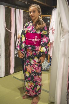 A pretty girl in a kimono. Kimono is the traditional dress worn popular in Japan.European girl in kimono.Portrait of girl wearing japanese traditional kimono .