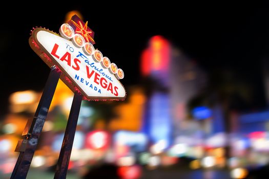 Famous Las Vegas sign at night with Las Vegas Cityscape blur background.