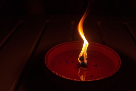 Candle flame close up on dark background, interesting flame figure, candle fire shape, horizontal