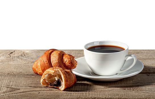 Coffee and croissants on a wooden table. Broken croissant. Isolated on white background.