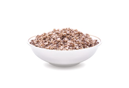 Buckwheat boiled in white deep plate. Isolated on white background.