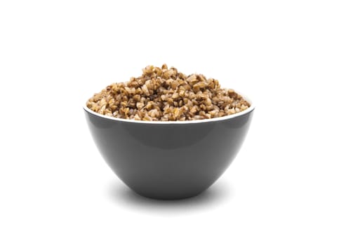 Dry buckwheat in grey color ceramic bowl isolated on white background. Isolated on white background.