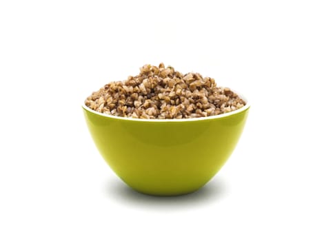 Dry buckwheat in yellow color ceramic bowl isolated on white background. Isolated on white background.