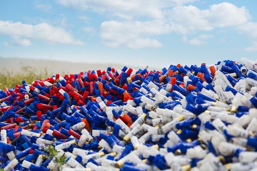 CHISINAU, MOLDOVA - October 3, 2018: Shotgun shells on blue sky background. Background of many colorful shot empty shotgun shells, blue, red, yellow, purple colored