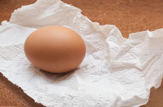 Single chicken egg on a white paper napkin