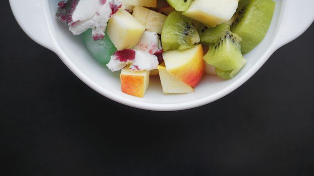 Close up desert with fresh fruit and ice cream. Mixed Fruit With Ice Cream and fruit ice on black background