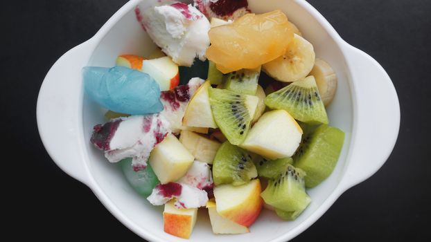 Close up desert with fresh fruit and ice cream. Mixed Fruit With Ice Cream and fruit ice on black background