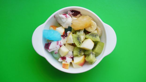 Close up desert with fresh fruit and ice cream. Mixed Fruit With with fruit ice on green background