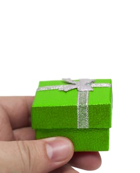 Hand holding small green collour gift with silver ribbon isolated on white background