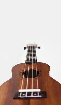 The brown ukulele guitar isolated on the white background. Blurred concept