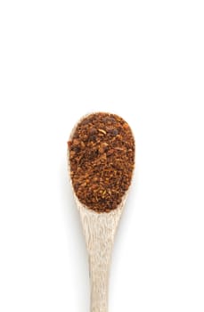Ground red chili pepper paprika spice in wooden spoon isolated on white background