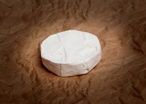 Fresh Camembert cheese is a natural, on Kraft paper brown background. With clipping path