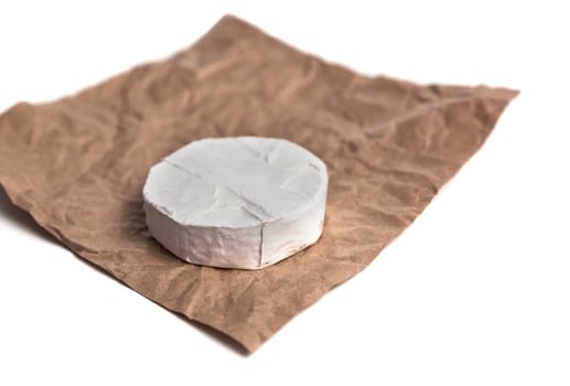 Fresh Camembert cheese is a natural, on Kraft paper brown background. With clipping path