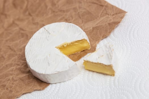 Fresh slice Camembert cheese natural, on Kraft paper brown background. With clipping path