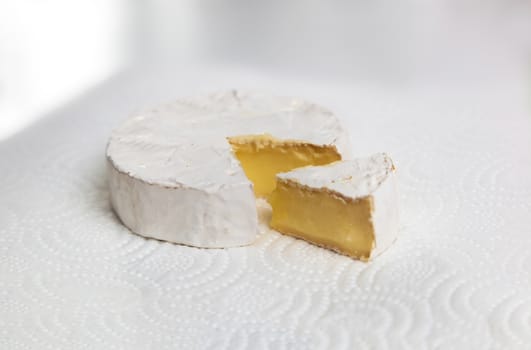Fresh slice Camembert cheese natural, on white paper background. With clipping path