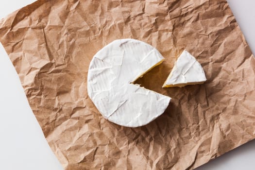 Fresh slice Camembert cheese natural, on Kraft paper brown background. With clipping path