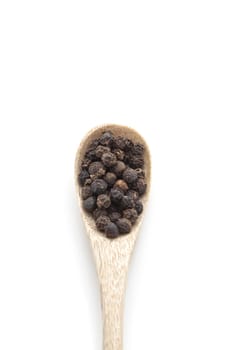 black pepper corns in wooden spoon isolated on white background