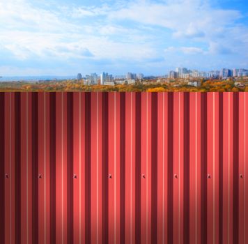 Fence made of metal panels a red color outdoors
