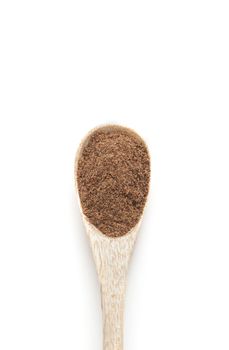 Ground nutmeg spices in wooden spoon isolated on white background