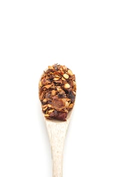Red hot chili flakes in wooden spoon isolated on white background