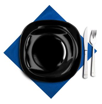 Black plate, fork and knife on blue napkin. Isolated on white.