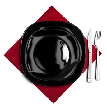 Black plate, fork and knife on red napkin. Isolated on white.