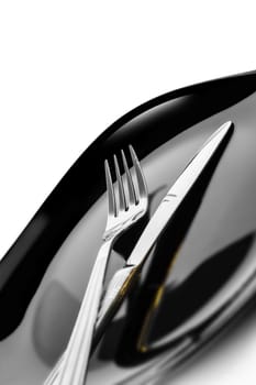 Knife and fork at plate on white background