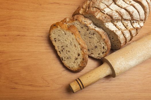 Sliced rye bread with linseed on wooden background.