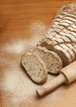 Sliced rye bread with linseed on wooden background.