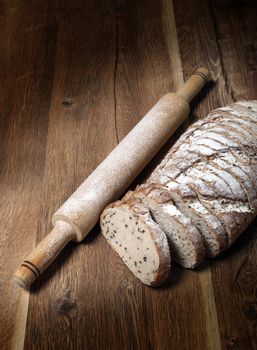 Sliced rye bread with linseed on wooden background.