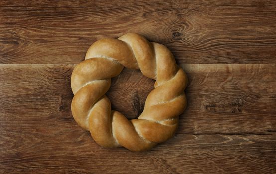 Braided round bread on wooden background. With clipping path