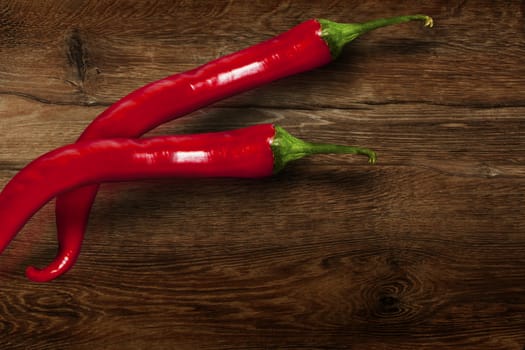 Red chili pepper isolated on wooden background.