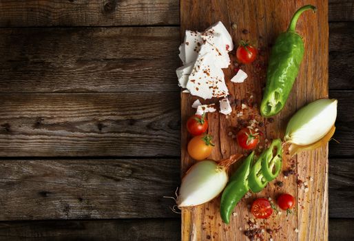 Table top full of fresh vegetables, cheese, traditional Balkan foods with a space in the for text.