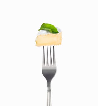 Fresh slice Camembert cheese on a fork isolated on white background