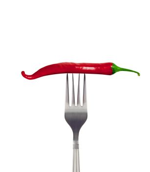 Red hot chili pepper speared onto metal fork shot on white background. With clipping path