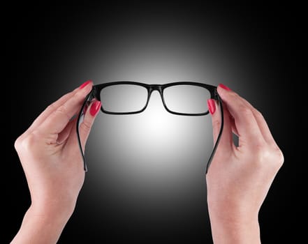 Black Eye Glasses in women's hand Isolated on black background