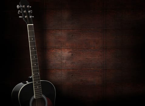 Black acoustic guitar on dark red wooden background.