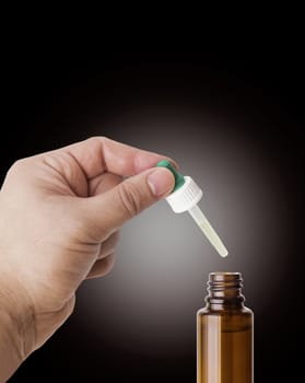 Hand man scientist, doctor keeps the pipette for drop over the container with liquid, medication or chemical substance laboratory. Isolated on white background with clipping path