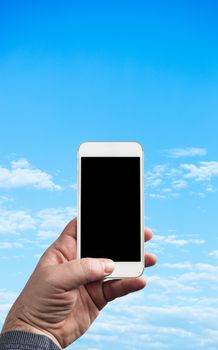 Man Hand holding mobile phone photographing blue sky with clouds