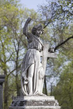 Angel and cross monument on a very old grave.