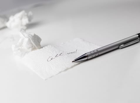 Napkin With Scribbled text, paper ball and Pen on Table on white background