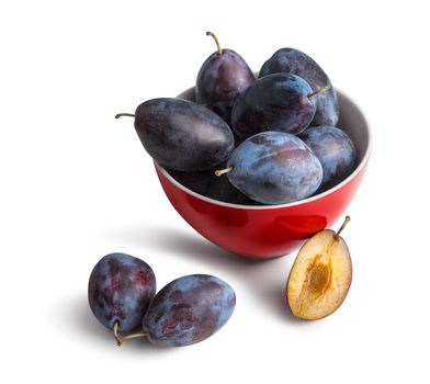 Fresh organic plums in ceramic bowl isolated on white background